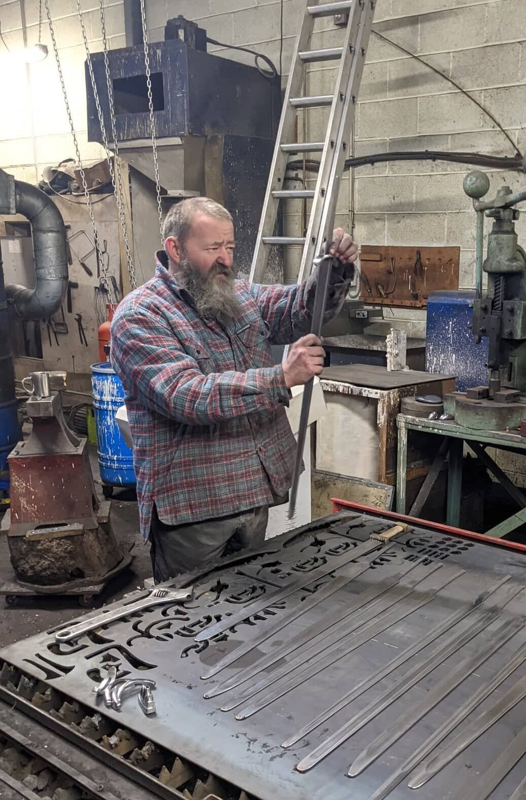 Shows plasma table and various bits of workshop machinery and me examining a sword and hilt.