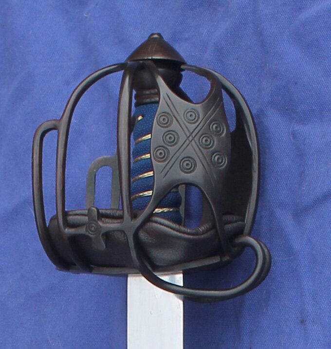 Browned hilt with cup and ring markings on the panels. Rayskin grip with brass wire and leather pad liner. Side view