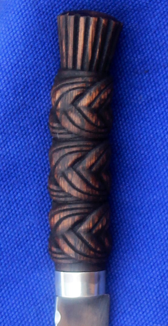 Hilt in oak with 3 bands of pleated knotwork and silver ferrule.
