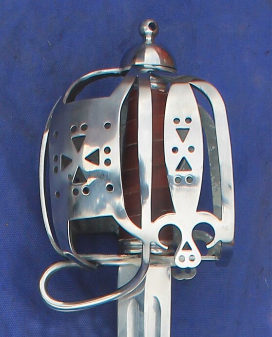 Polished side view of a full basket Dragoon. Panels decorated with circle and triangle punched holes.